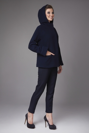 Beautiful sexy attractive young woman with dark hair wearing a strict business suit black skinny pants short coat with wide sleeves black high-heeled shoes clothes for autumn walks business meetingの写真素材