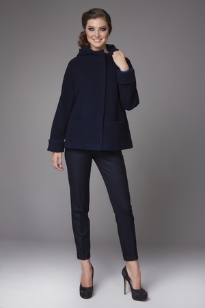 Beautiful sexy attractive young woman with dark hair wearing a strict business suit black skinny pants short coat with wide sleeves black high-heeled shoes clothes for autumn walks business meetingの写真素材