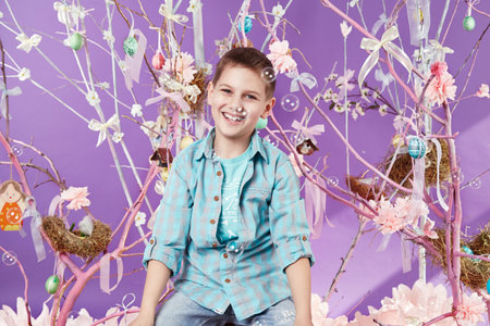 Little fluffy Easter bunny sitting in a wicker basket on a background of violence sky and spring...