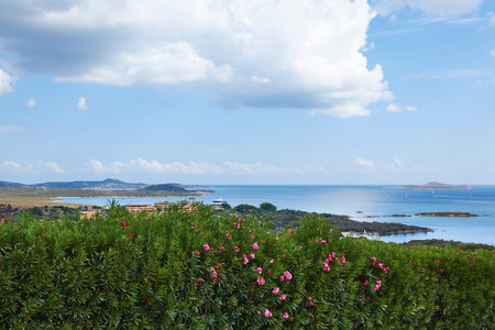 Beautiful summer view on the sea beach and mountain where is paved road and skyline with clouds and greenery trees from Italian Sardinia the best view on the island bay area from traveling vacation.の写真素材