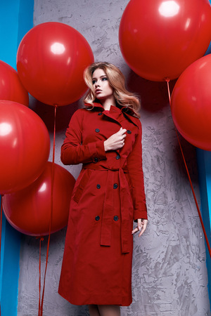 Beauty woman model wear stylish design trend clothing natural organic cotton coat red trench outerwear casual formal office style for work meeting walk party brunette hair makeup romantic big balloon.の写真素材