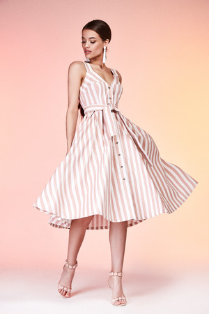 Pretty beautiful sexy elegance woman skin tan body fashion model glamor pose wear silk lilac dress casual clothes party summer collection makeup hair style brunette success accessory jewelry studio.の写真素材