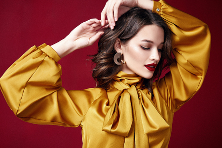 Portrait beautiful sexy pretty woman red lipstick jewelry earrings brunette hair cosmetic makeup fashion clothes beauty salon happy holidays merry Christmas Eve New Year St. Valentine's Day party.の写真素材