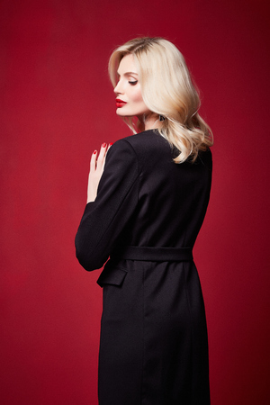 Beautiful sexy pretty woman red lipstick jewelry earrings blond hair cosmetic makeup fashion wear clothes style beauty salon happy party style Valentine's red background accessory brunette.の写真素材