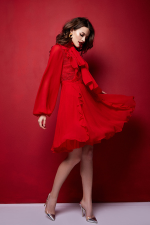 Beautiful young sexy woman thin slim figure evening makeup fashionable stylish dress clothing collection, brunette, gifts boxes red silk bows holiday party birthday New Year Christmas Valentine's Day.の写真素材