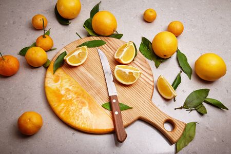 Exclusive painted art cutting board made of wood organic serving dishes with taste food cuisine fresh orange fruit green leaves cut knife juice.の写真素材