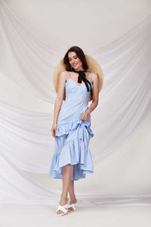 Beautiful tender young woman sexy brunette bride in a luxury white wedding dress lace chiffon Summer happiness awaits the groom before the wedding ceremony makeup accessory jewelry smile.の写真素材