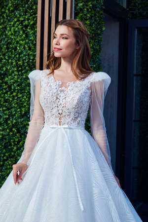 Sexy beautiful brunette woman pretty bride wedding big day marriage ceremony in summer garden wearing long silk and lace white dress bright makeup hairstyle pure love interior.の写真素材