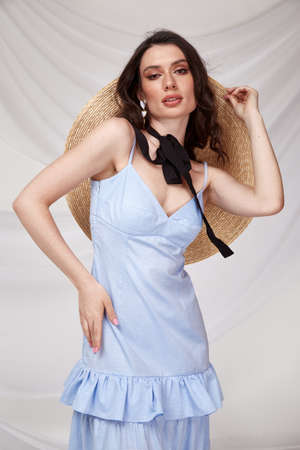 Beautiful sexy brunette woman wear summer collection dress style cruise collection fashion model silk textile elegant clothes makeup cosmetic glamor studio accessory hat.の写真素材