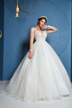 Sexy beautiful brunette woman pretty bride wedding big day marriage ceremony in summer garden wearing long silk and lace white dress bright makeup hairstyle pure love interior.の写真素材