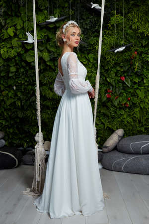 Beautiful woman bride fashion model blond hair bright makeup pretty wear long silk white dress with lace bridal ceremony wedding espousal in blooming romance garden party marriage happy big day.の写真素材