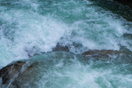 A fast, wild little river running over a lot of big stonesの写真素材