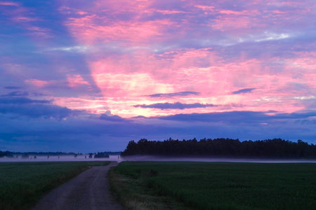 The sun goes out via great clouds at sunset with a beautiful mist beneath it