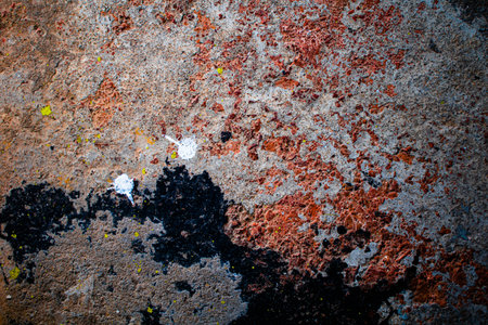 Beautiful abstract black and red spotted, rough stone cement wall background colorful image in warm...