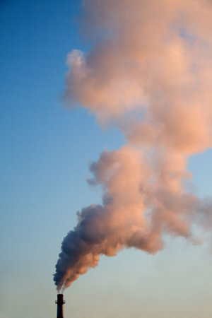 Smoke from the pipe. Against the backdrop of the evening sky.の写真素材
