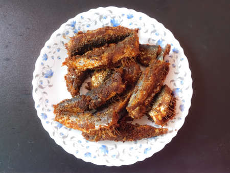delicious Kerala style fish fries in a plate on black background closeup viewの写真素材