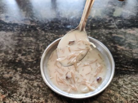 Selective focus on sweet delicious payasam or stew with a spoon over a plate contains stew ,closeup...