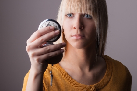 Young woman looking into a mirrorの写真素材