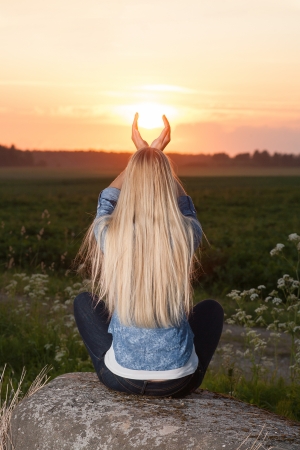 Blonde woman touching the sunの写真素材