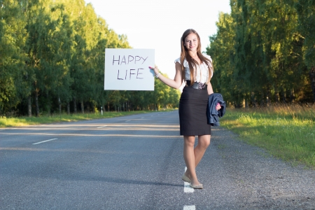 Woman hitchhikes for happy lifeの写真素材