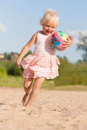 Cute little girl having fun with  beach ballの写真素材