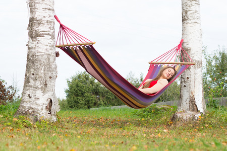 Beautiful young woman sleaping in colorful hammockの写真素材
