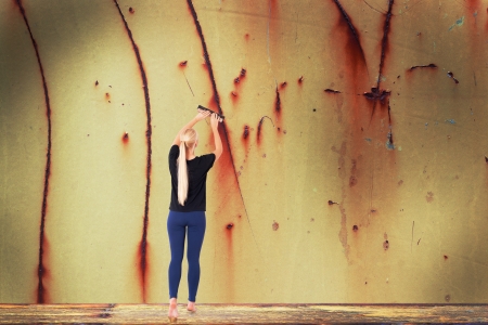 Young woman removes rust from metal wallの写真素材