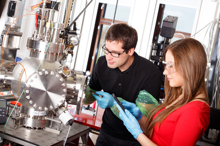 Scientists working with laser deposition chamberの写真素材