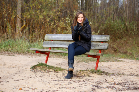 Woman feeling cold on beach benchの写真素材
