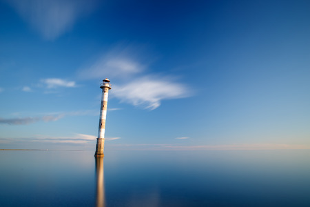 Skewed lighthouse in waterの写真素材