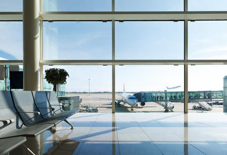 Airport terminal, people going to airplane in backgroundの写真素材