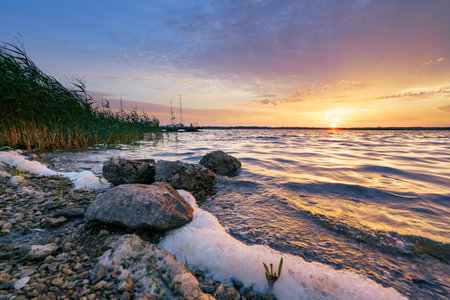 Beautiful coastal sunset, waves in waterの写真素材