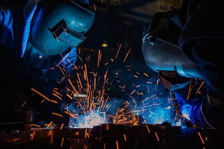 Workers are welding assembly steel part in factoryの写真素材