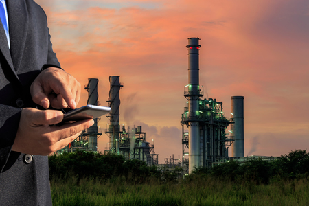 businessman is use smartphone check system at gas turbine electric power plantの写真素材