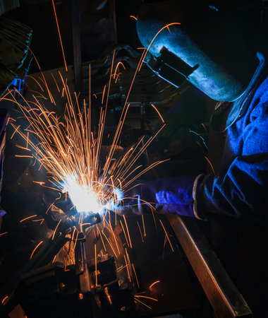 Welder at work. The welder is welding metal with sparks.