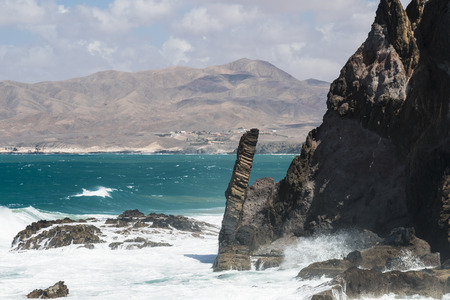 View of the northern coast of Jandia with its volcanic rock formations and tall waves in Fuerteventura, Spainの写真素材