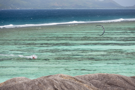 LA DIGUE - AUGUST 12: A kitesurfer in the lagoon of Anse Source D'Argent in La Digue, Seychelles on August 12, 2014のeditorial素材