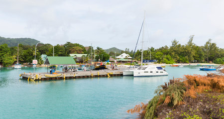 LA DIGUE - AUGUST 09: Boats and people in the harbor of La Digue, Seychelles on August 09, 2014のeditorial素材