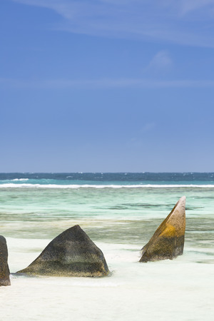 A beautiful scenic granite rock at Anse Source D'Argent in La Digue, Seychelles with clear lagoon and blue skyの写真素材
