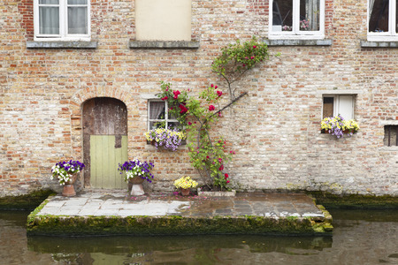 A typical old house in Bruges with a little canalside terrace, Belgium.の写真素材