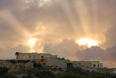 Sunbeams breaking through the clouds in M'Garr, Gozo, Malta.の写真素材