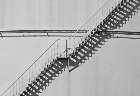 Stairs to the top of an oil tank with shadows.の写真素材