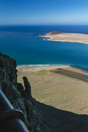 View from the Mirador del Rio in Lanzarote, Spain to the Isla La Graciosa with the volcano Montana Amarilla the tall cliff in the foreground.の写真素材