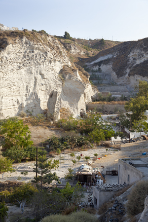Houses built with caves into the pumice stone hills in the little village Vothonas with blue sky. Santorini, Greece.のeditorial素材