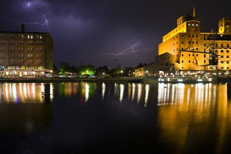 The modernized inner harbor area in Duisburg, Germany during a thunderstorm with reflection.のeditorial素材