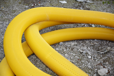 A long yellow tube laying on the ground on a construction site.の写真素材