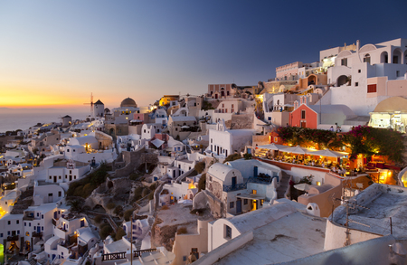 The famous windmills of Oia in the west of Santorini with a colorful sunset.のeditorial素材