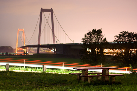 A rather unusual resting place near the famous suspension bridge in Emmerich, Germany. Long exposure with light trails, focus on foreground.の写真素材