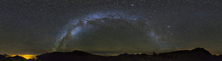 Panorama view of the milky way above the Caldera de Taburiente in La Palma, Spain with a photographer to the right.の写真素材