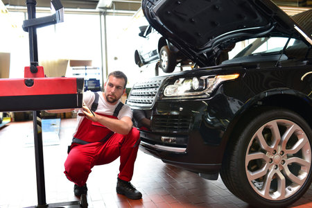car repair shop - worker checks and adjusts the headlights of a car's lighting system